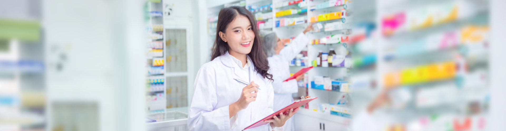 Beautiful pharmacist holding chart and smiles in drugstore